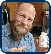 Adult man smiling and holding an iGenics eye health support supplement bottle